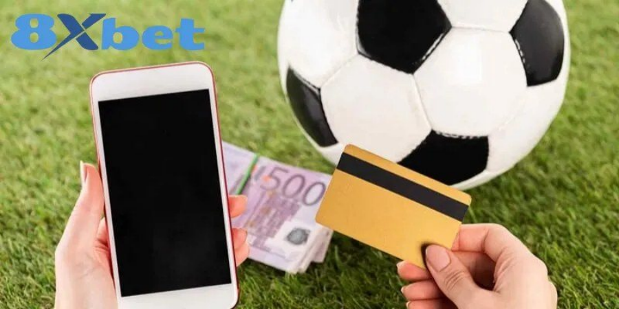 Điện thoại và thẻ ngân hàng minh họa việc theo dõi kết quả cược hằng ngày