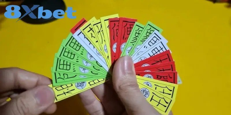 Xòe bài tứ sắc trên tay với các lá vàng, đỏ, xanh, trắng